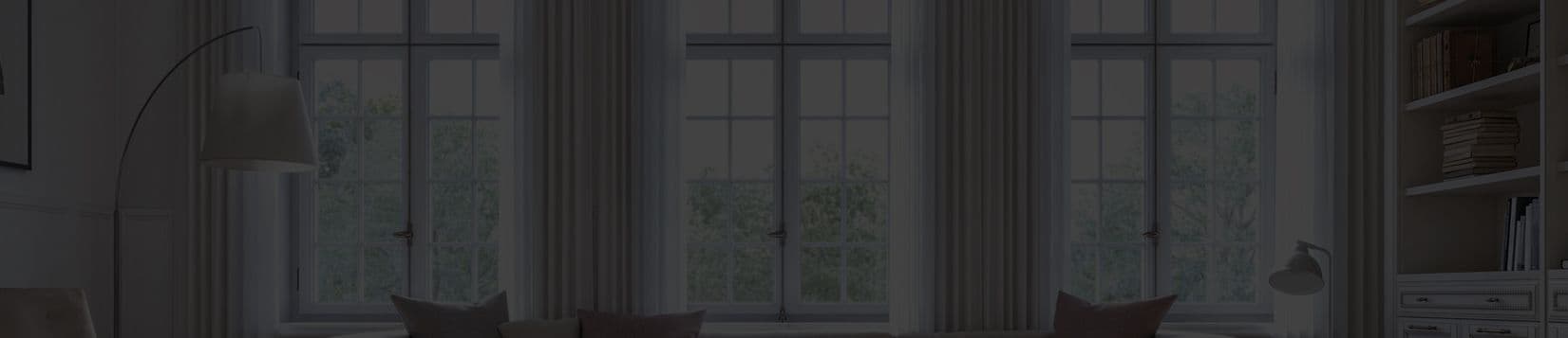 Hinged windows with curtains as seen from the inside.