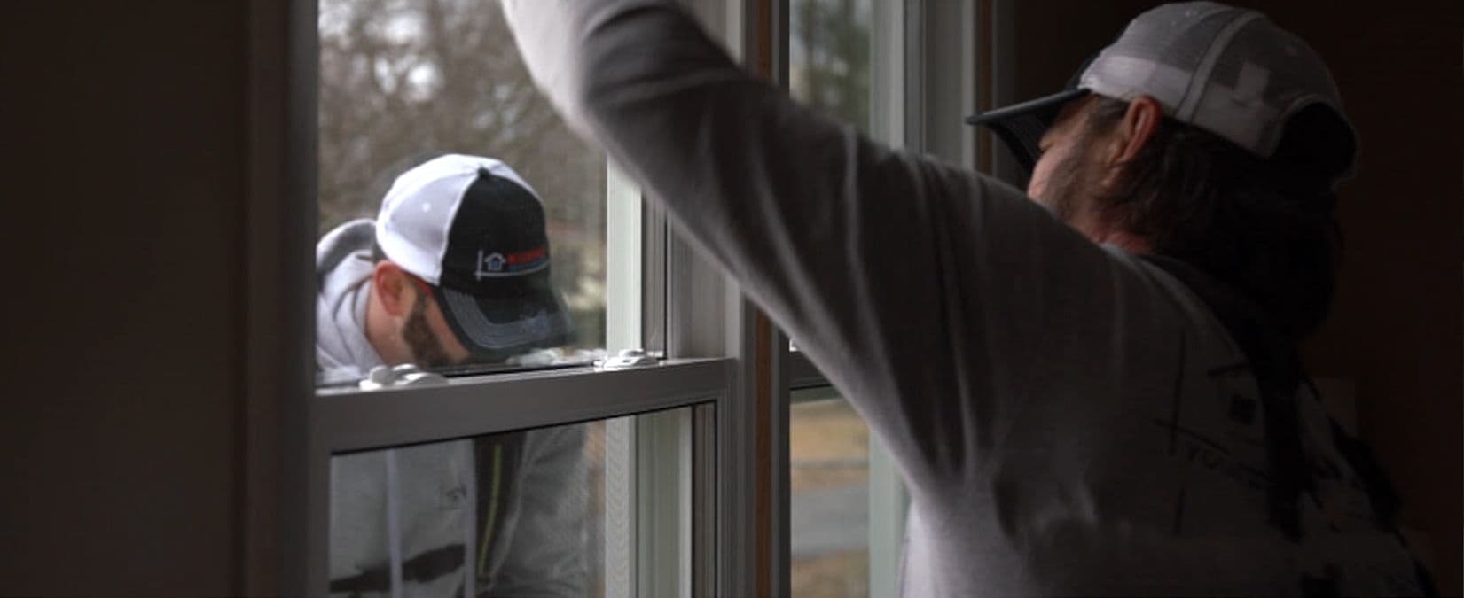 A still of Kubala Home Improvement workers installing a new window.